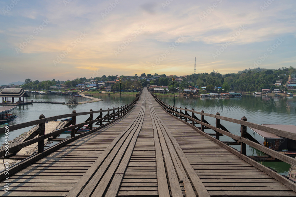 Wooden Mon Bridge with residential local houses in Mon village, nature trees, Sangkhlaburi, Kanchanaburi, Thailand in urban city town in Asia, buildings.