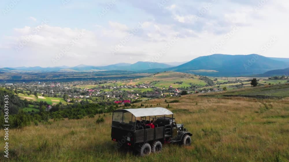 The truck is traveling along a mountain road on tourist route. A tourist trip through Ukrainian Carpathians in the summer. Big green tourist car Zil. Rest in nature among the river and green forests. The truck is traveling along a mountain road on tourist route. A tourist trip through Ukrainian Carpathians in the summer. Big green tourist car Zil. Rest in nature among the river and green forests.