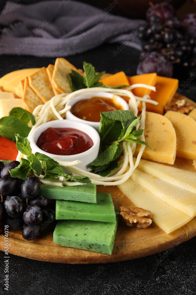 Cheese plate, wine, glasses. Cheeses, nuts, grapes, mint, sauces, honey snacks for red wine. Bar, menu, restaurant. Background image, copy space Cheese plate, wine, glasses. Cheeses, nuts, grapes, mint, sauces, honey snacks for red wine. Bar, menu, restaurant. Background image, copy space