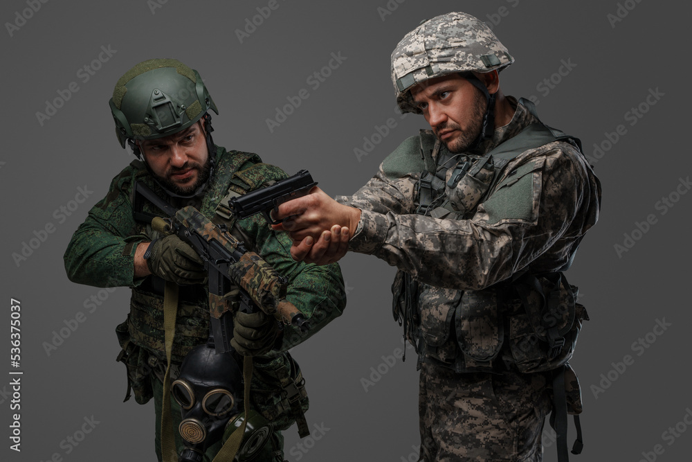 Shot of russia and nato soldiers aiming their guns isolated on gray background. Shot of russia and nato soldiers aiming their guns isolated on gray background.
