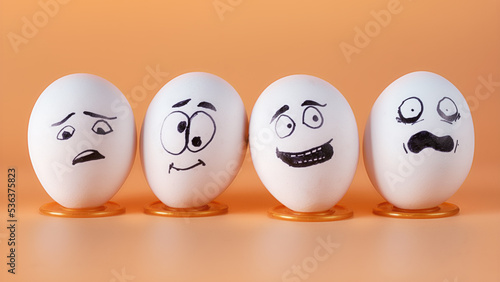 Four eggs with painted funny faces representing people in different emotional states
