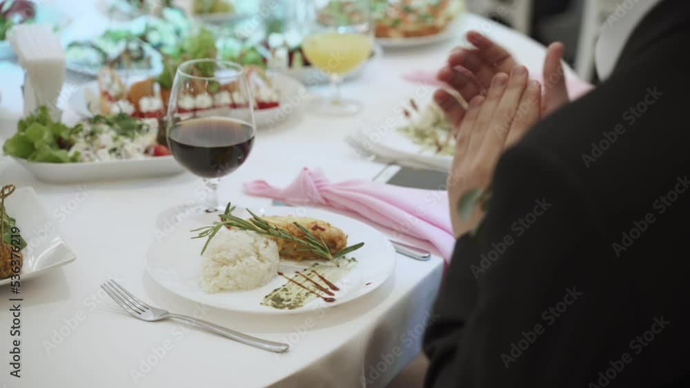 Hot dish on banquet table. Unrecognizable man claps, close-up. Hot dish on banquet table. Unrecognizable man claps, close-up.