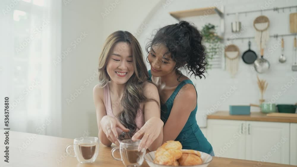 Holiday concept of 4k Resolution. Asian women having coffee together in the kitchen. Young women are in a mutual lesbian love relationship. Holiday concept of 4k Resolution. Asian women having coffee together in the kitchen. Young women are in a mutual lesbian love relationship.