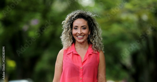 Portrait hispanic woman smiling outside at park, casual real people