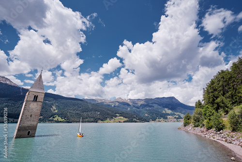 Beautiful view of the lake Resia. Famous tower in the water. Alps, Italy, Europe.