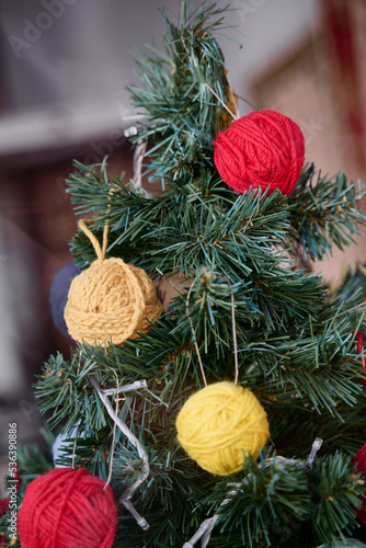Christmas decor. Balls of thread on the branch of xmas tree.