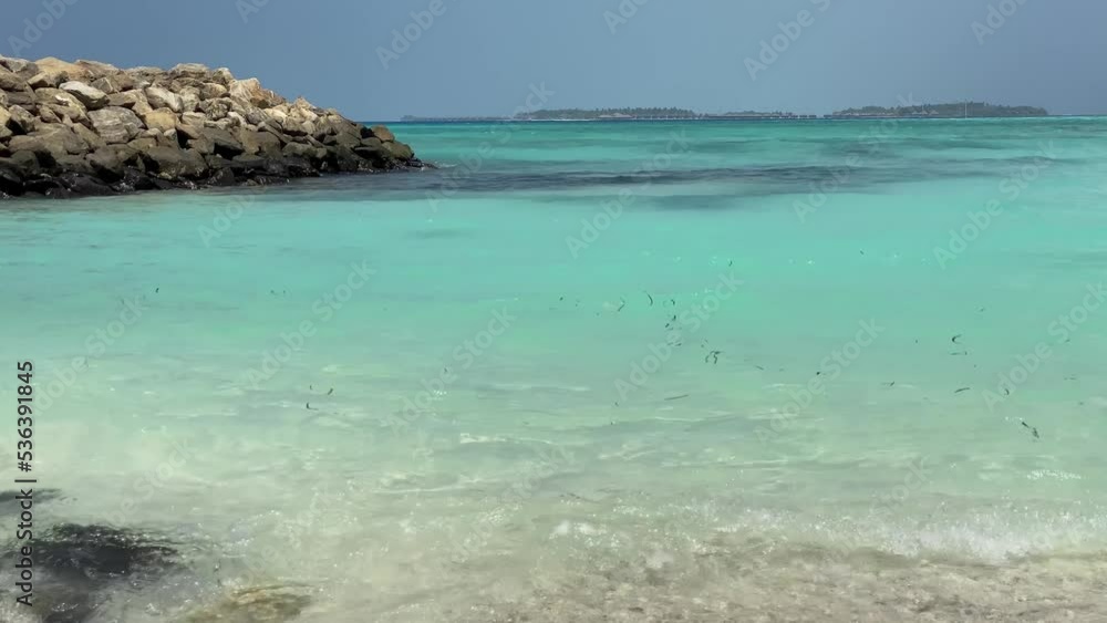 View from the beach to the Indian Ocean in the Maldives. Small waves in the turquoise sea. Calm View from the beach to the Indian Ocean in the Maldives. Small waves in the turquoise sea. Calm