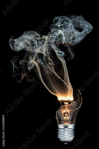 Bild auf Leinwand Vertical closeup shot of a burned-out light bulb with smoke coming out
