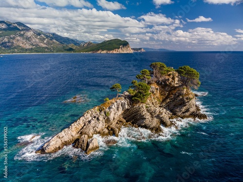 High-angle of Sveta Nedjelja island in an open sea with rocky and forested beach background photo