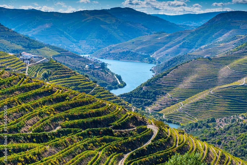 Naklejka premium Scenic aerial view of Douro River surrounded by mountains on a sunny day