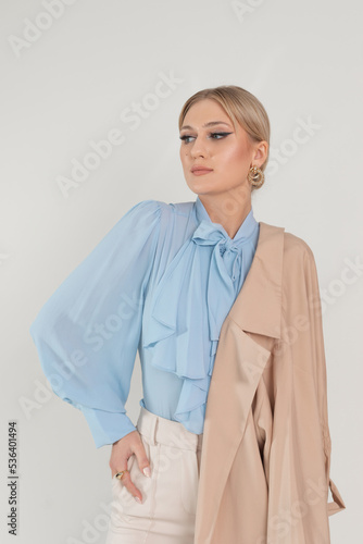 Attractive confident blond businesswoman in formal trendy outfit with jacket on shoulder. Fashionable clothes collection