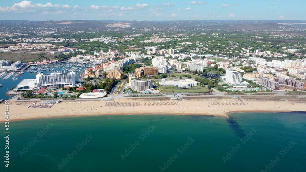 Vilamoura, PORTUGAL: September 18 2022: Aerial view of Villamoura beach. Luxury hotel Tivoli with beautiful Vilamoura marina in background. Drone backward. Beautiful panorama of the Vilamoura city Vilamoura, PORTUGAL: September 18 2022: Aerial view of Villamoura beach. Luxury hotel Tivoli with beautiful Vilamoura marina in background. Drone backward. Beautiful panorama of the Vilamoura city