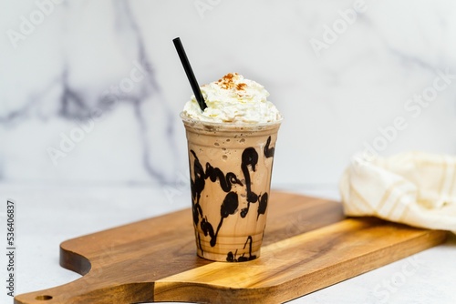 Картината върху платно Tasty fresh Frappuccino with cream served on the wooden board