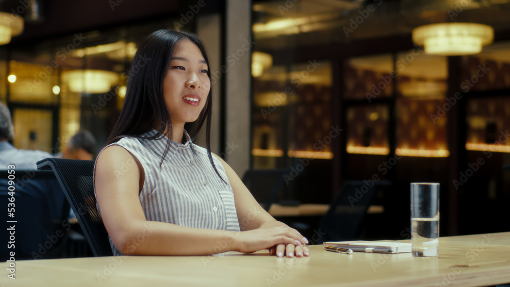 Asian woman talking online with client, having video call, working in modern office of marketing company. Virtual business meeting. Advertising and sale of products
