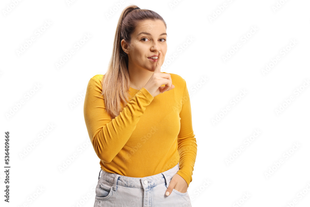 Young woman gesturing silence with finger over mouth Young woman gesturing silence with finger over mouth