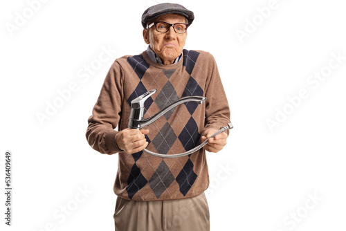 Confused elderly man holding a steel hose with water tap