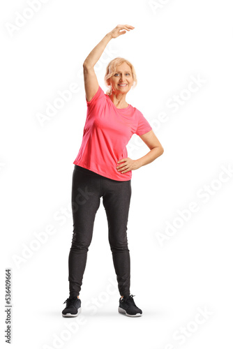 Full length pоrtrait of a mature woman stretching upper body