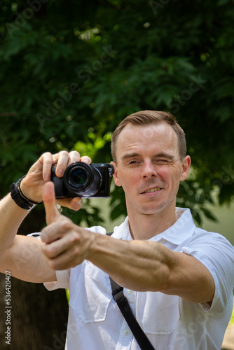 A young man walks and photographs nature