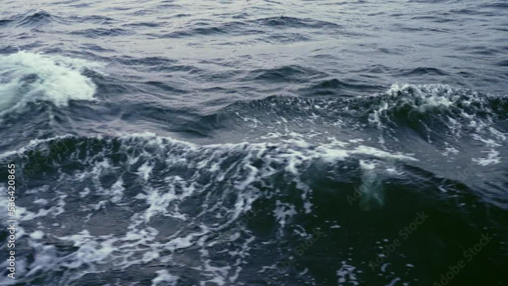 Close up with slow motion sea splash waves from sailing yacht. Dark sea waves. Close up with slow motion sea splash waves from sailing yacht. Dark sea waves.