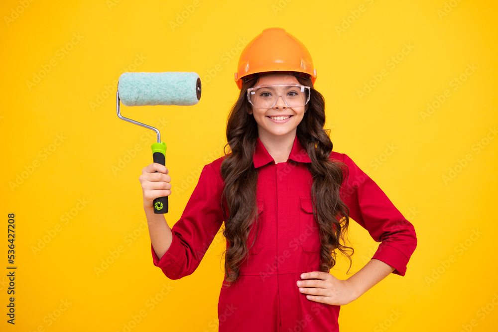 Painter in workshop. Renovation and repair. Teen girl in helmet with painting brush. Child in hard hat. Kid builder painter on construction site. Happy positive and smiling emotions of teenager girl. Painter in workshop. Renovation and repair. Teen girl in helmet with painting brush. Child in hard hat. Kid builder painter on construction site. Happy positive and smiling emotions of teenager girl.
