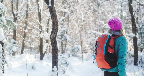 Woman hiker backpacker traveler walking in winter woods with sunlight on sunny day. Snow Day Fun. Health care, authenticity, sense of balance. 4K slow motion.	