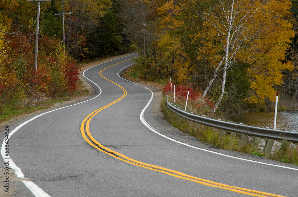 Fototapeta premium Travelling on a curved road in the mountains during fall season