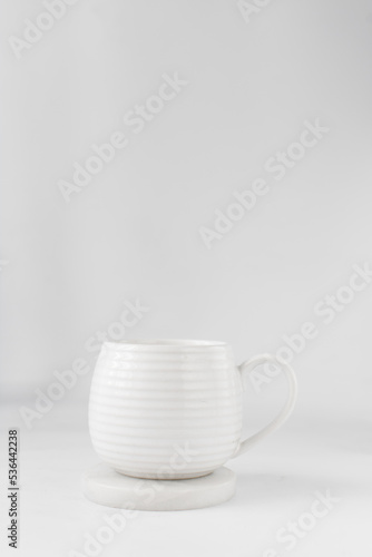 white ceramic cup on a white marble saucer, white teacup