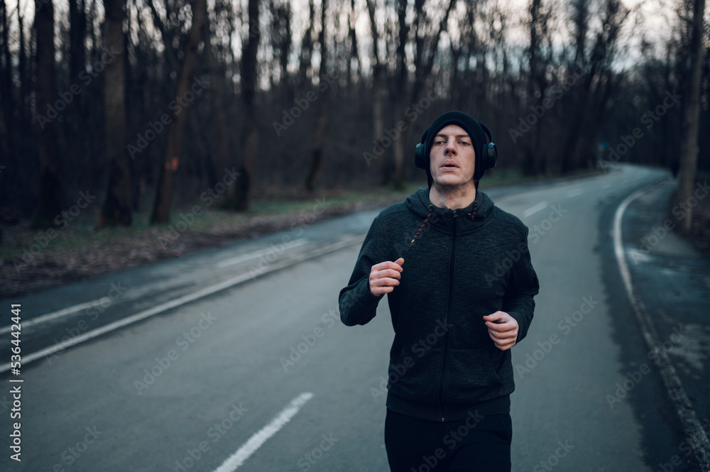 Fototapeta premium Redhead young man running outside on a mountain road