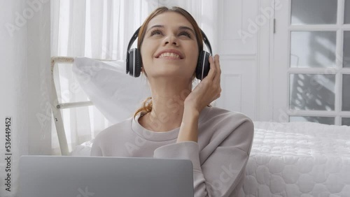 Wallpaper Mural Happy young woman wearing headphones listening music while using laptop computer and singing with fun and enjoy in the living room, happiness female with entertainment, lifestyles concept. Torontodigital.ca