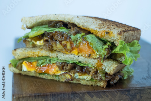 Sandwich on a cutting board. Pieces of appetizing of shortplate beef. photo