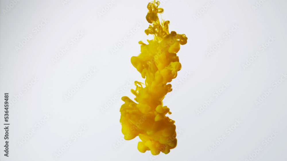 Abstract formed yellow color dissolving water. Abstract cloud ink swirling water. Royalty high-quality stock photo Acrylic ink underwater form, abstract smoke pattern isolated on white background
