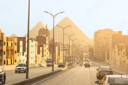 Cairo street with pyramids in the background