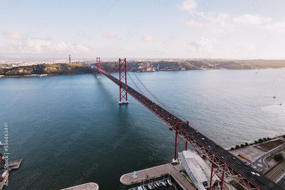 Aerial view of 25 de Abril bridge over the Tagus River at sunset in Lisbon, Portugal.
