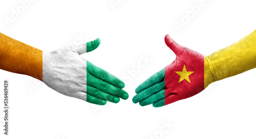 Handshake between Cameroon and Ivory Coast flags painted on hands, isolated transparent image. photo