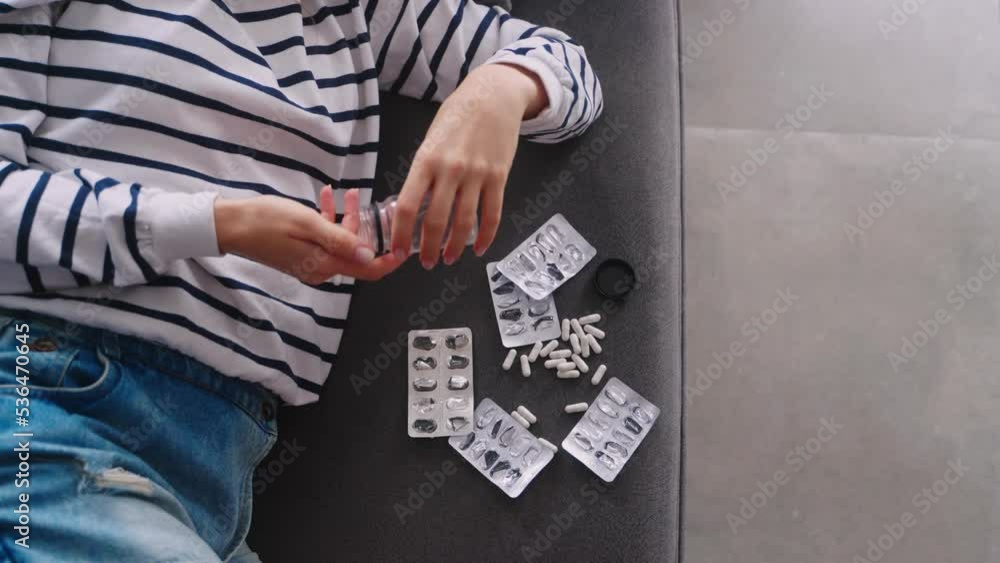 Woman committing a suicide by drug overdose, drops a jar of pills