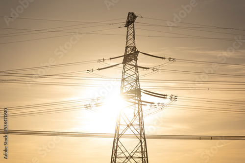 Gleißendes Sonnenlicht überstrahlt einen Strommasten. photo