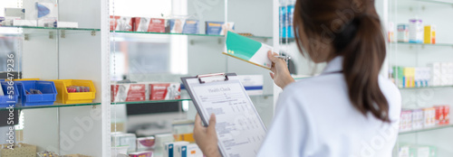 Pharmacist women are supplying prescription drugs to customers, Pharmacists work in a pharmacy, Drug store shelf with prescription medication, Clipboard at the hospital pharmacy, Community Pharmacy.