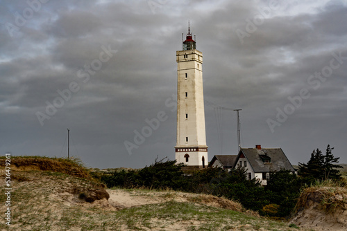 Blåvandshuk Lighthouse at the westernmost point on Denmark under a dramatic autumn sky photo
