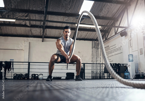 Man, workout and fitness with rope at gym for health, exercise and body wellness. Healthy, muscle and strong for development for athlete in mma, wrestling or sport at training club, class or studio © Tashriq P/peopleimages.com