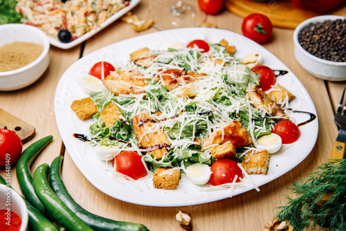 Healthy Caesar salad of chicken with tomatoes and croutons. Restaurant serving dishes on a plate.