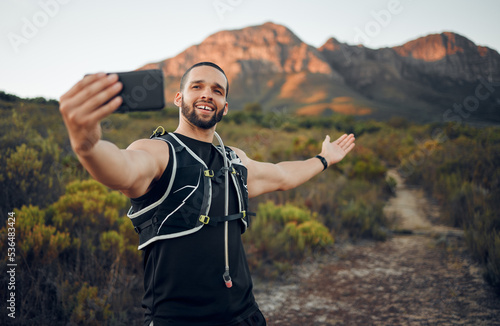 Selfie, athlete and man with smartphone in nature on trail smile, happy and healthy doing exercise and workout. Fitness influencer, health or wellness outdoor calm, peaceful or while training outdoor
