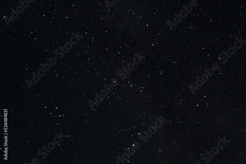 Many stars on black sky at night. A real dark night sky with plenty of stars. Night sky background with selective focus