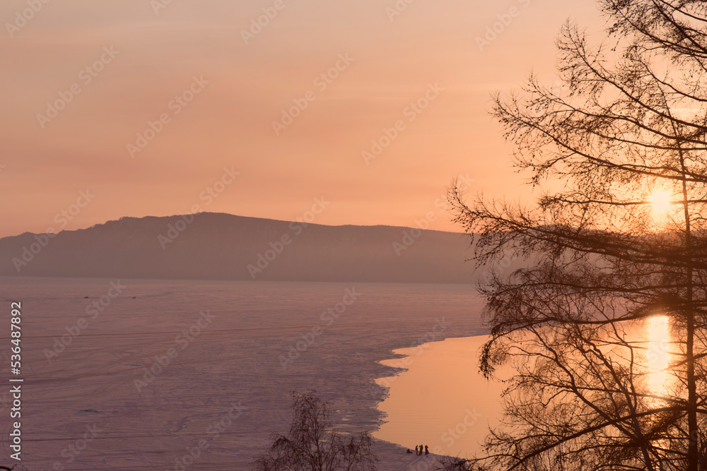 Beautiful sunset on frozen lake Baikal. Winter landscape.