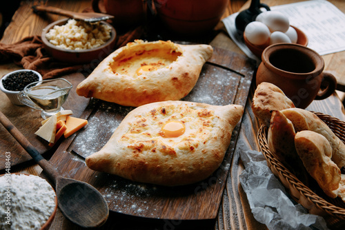 Traditional Georgian cuisine, restaurant serving. Adjarian khachapuri on a wooden board.