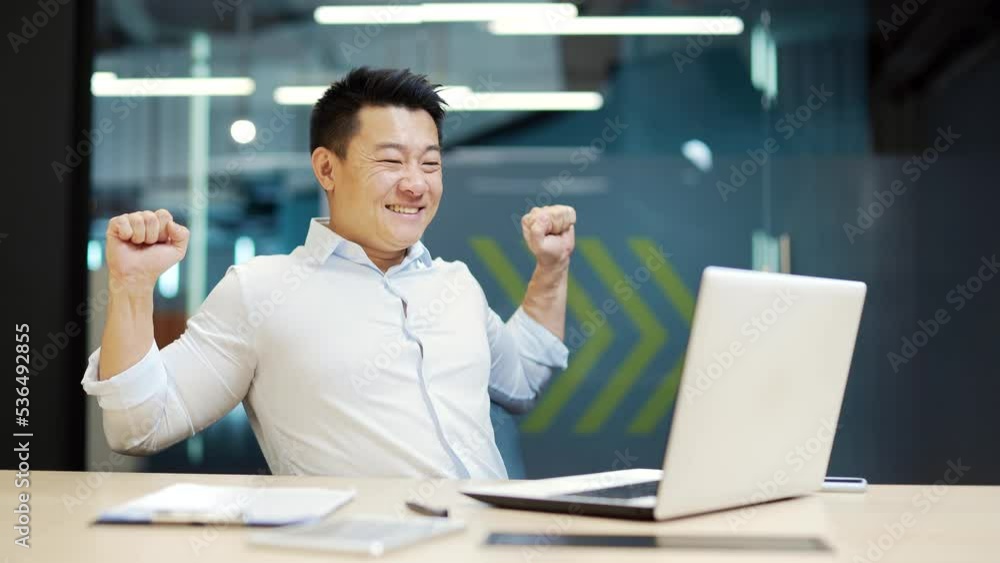 Satisfied Employee with the result successful completion of a project or job. Happy glad Asian office worker business man sitting in office at workplace working on laptop computer. work is done Satisfied Employee with the result successful completion of a project or job. Happy glad Asian office worker business man sitting in office at workplace working on laptop computer. work is done