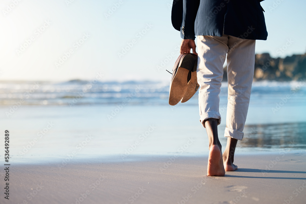 Walking, beach and mental heath with a business man walking in the sand by the sea or ocean after work. Water, nature and freedom with a male employee taking a walk on the coast during summer - obrazy, fototapety, plakaty 