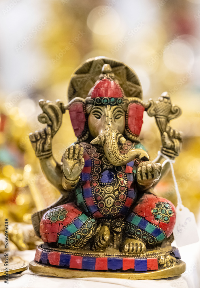 Lord Ganesh idol made with brass with blur background. Selective focus on sculpture.