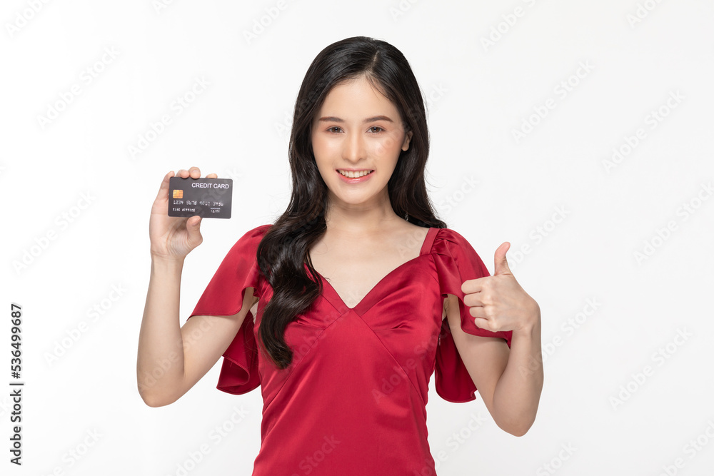 Asian young woman in red dress holding credit card smile thumbs up. Confident female with black hair happiness and proud with credit card in hand isolated on white for used with product advertising Asian young woman in red dress holding credit card smile thumbs up. Confident female with black hair happiness and proud with credit card in hand isolated on white for used with product advertising