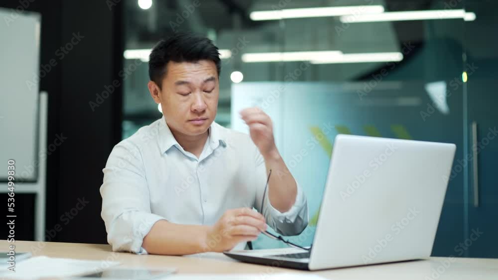 Exhausted, overworked asian man office worker severe headache employee eyes hurt massaging his head poor vision, sore eyes Tired male employee in pain ache Stress sedentary working computer Exhausted, overworked asian man office worker severe headache employee eyes hurt massaging his head poor vision, sore eyes Tired male employee in pain ache Stress sedentary working computer