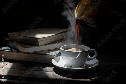 Coffee in a hot glass cup on a dark wooden floor
